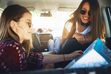 Eğlenceli roadtrip Haritaya bakarken iki genç kadın.