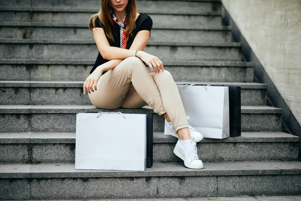 女性は買い物の後 階段に座っている 隣の紙袋 — ストック写真