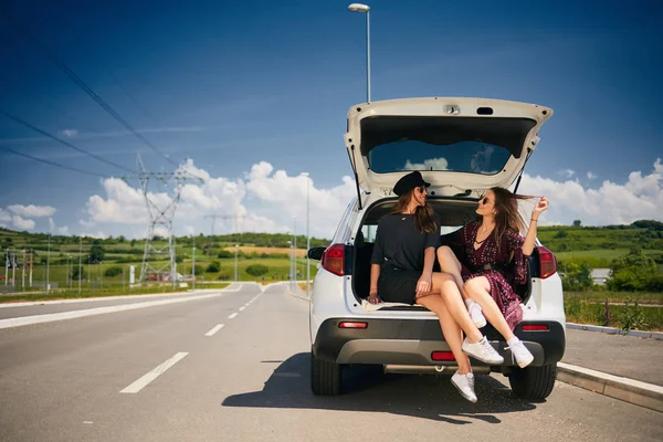 Duas Raparigas Sentadas Bagageira Falar Carro Estacionado Estrada — Fotografia de Stock