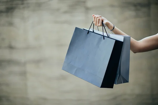 Hand Innehav Shoppingväska Väggen Bakgrunden — Stockfoto