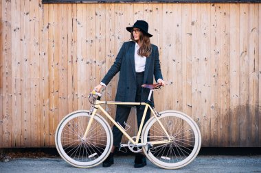 Güzel esmer holding Bisiklet portresi. Ahşap arka plan.