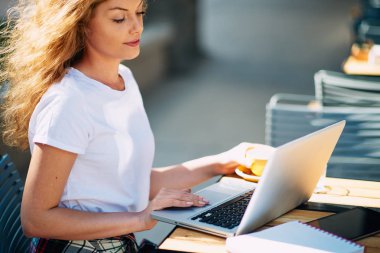 Kahve içme ve kafede otururken dizüstü kullanarak kız öğrenci.