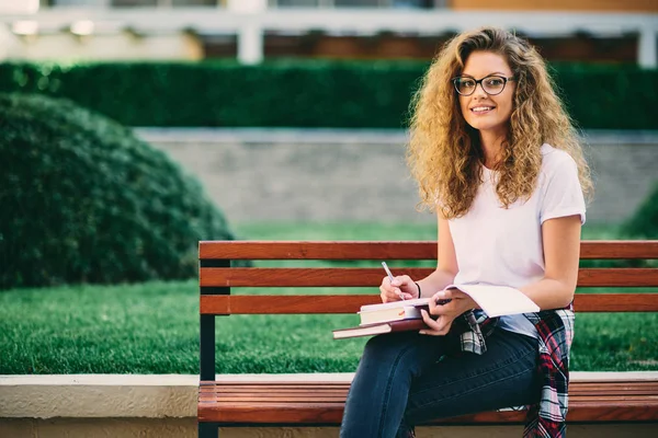 Kvinnlig Student Skriva Uppsats Medan Sitter Bänk Campus — Stockfoto