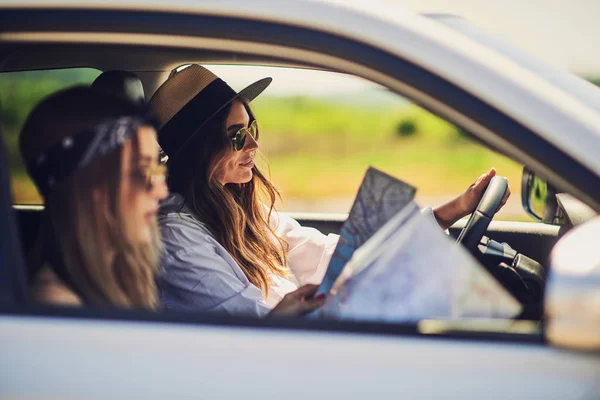 Duas Raparigas Divertirem Conduzir Uma Menina Dirigindo Outra Lendo Mapa — Fotografia de Stock