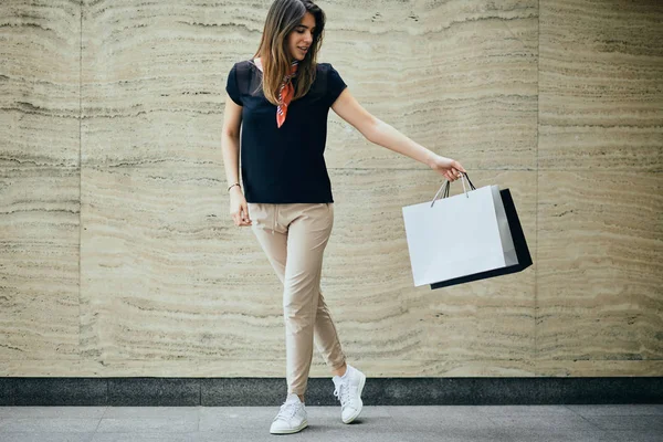 Happy young woman holding holding shopping bags.