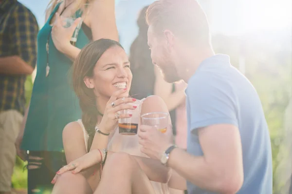 Couple sitting and drinking alcohol at outdoor party