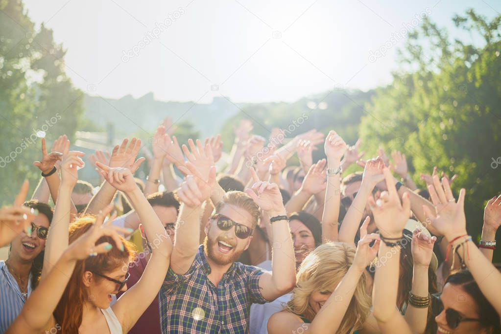 Group of people dancing and having a good time at the outdoor party/music festival