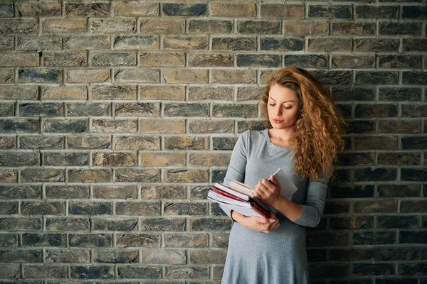 Kitap Bricka Duvar Önünde Tutan Kadın Portresi — Stok fotoğraf