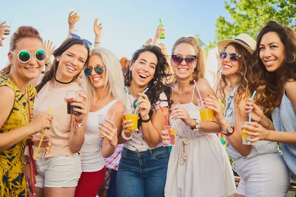 Group of female friends posing and having a good time at the outdoor party/music festival