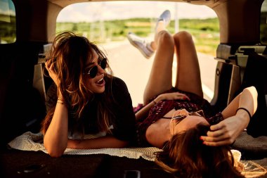 Bagaja yalancılık aşağı ve dinlenme araba kullanmaktan iki kız.