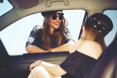 İki kadın sürüş bir mola. Araba ve araba penceresindeki diğer yaslanmış bir kadın.