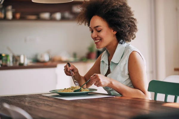 Schöne Mischlingshündin Isst Pasta Zum Abendessen Während Sie Küchentisch Sitzt — Stockfoto