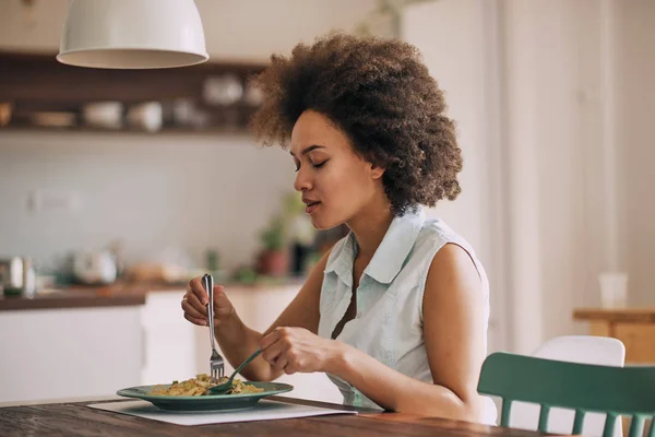 Schöne Mischlingshündin Isst Pasta Zum Abendessen Während Sie Küchentisch Sitzt — Stockfoto