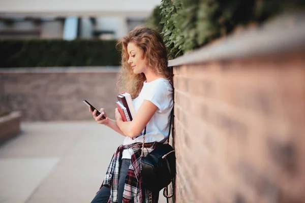 Estudiante Usando Teléfono Inteligente Sosteniendo Libros Mientras Camina Campus — Foto de Stock