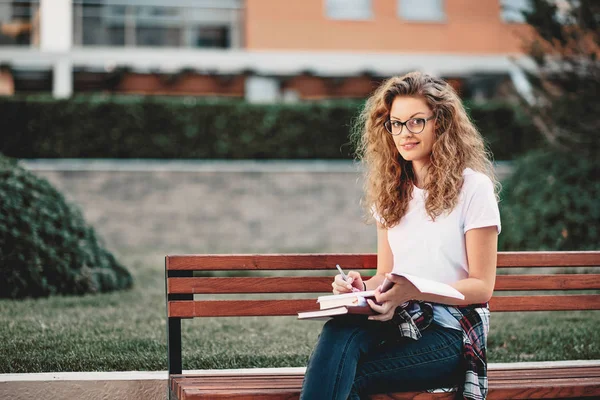 Esej Piśmie Kobiet Student Siedząc Ławce Kampusie — Zdjęcie stockowe