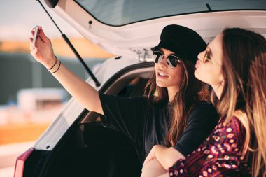 İki kadın bir bagaja selfie sittink süre alarak. Yol rtip konsepti.