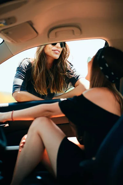 两个女人在开车时休息 一个女人在车上 其他靠在车窗上 — 图库照片