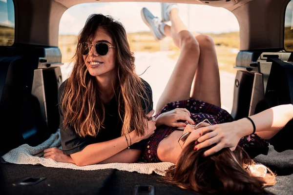 Bagaja yalancılık aşağı ve dinlenme araba kullanmaktan iki kız.