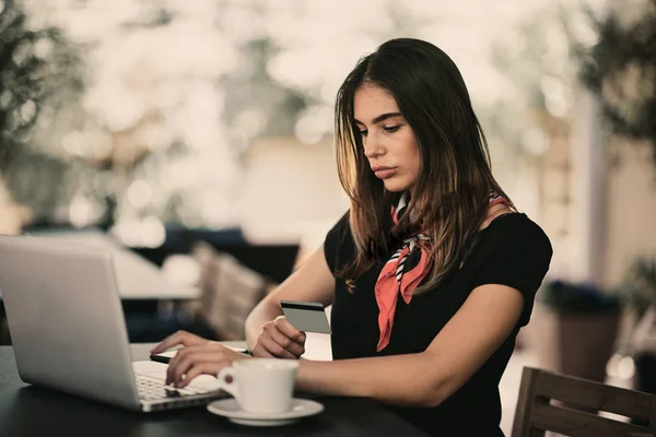 快乐的年轻妇女使用信用卡和笔记本电脑购物 而坐在咖啡馆 — 图库照片