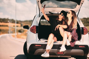İki kadın bir bagaja selfie sittink süre alarak. Yol gezi konsepti.