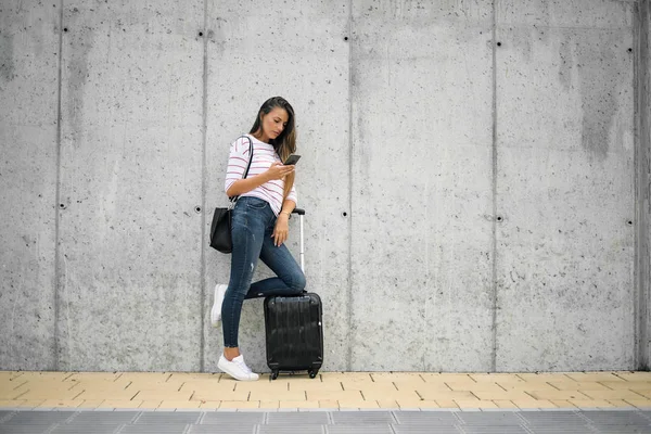 Mujer Usando Teléfono Inteligente Mientras Apoya Equipaje Calle —  Fotos de Stock