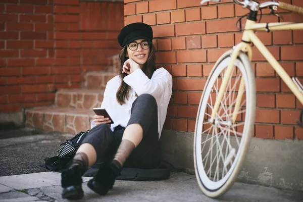 Mujer Sentada Acera Usando Teléfono Inteligente Junto Bicicleta Amarilla — Foto de Stock