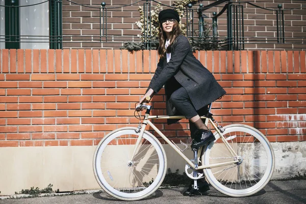 Şehrin bir bisiklet sürme genç modern kadın.