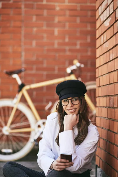 Жінка Сидить Тротуарі Використовує Смартфон Поруч Жовтим Велосипедом — стокове фото