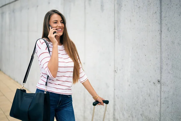 Žena Nesoucí Zavazadla Při Chůzi Stanici Pomocí Chytrého Telefonu — Stock fotografie