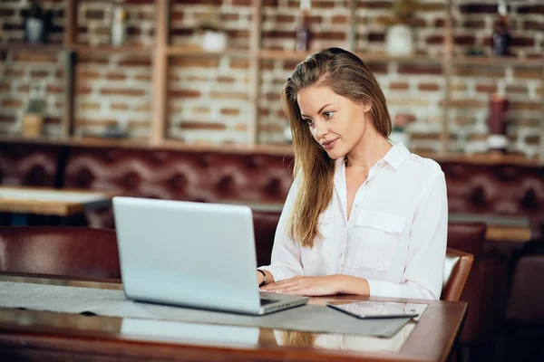 女实业家坐在自助餐厅时使用笔记本电脑工作 — 图库照片
