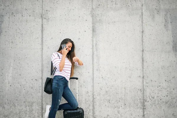 Mulher Usando Telefone Inteligente Enquanto Inclina Bagagem Rua — Fotografia de Stock