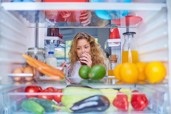 Женщина Нюхающая Варенье Перед Холодильником Полным Продуктов — стоковое фото