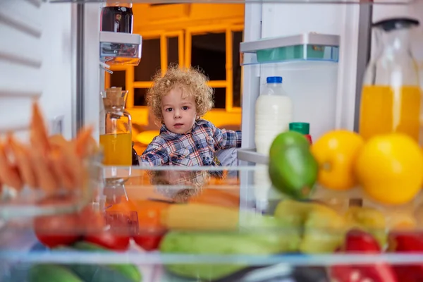 Toddler stealing food from fridge.