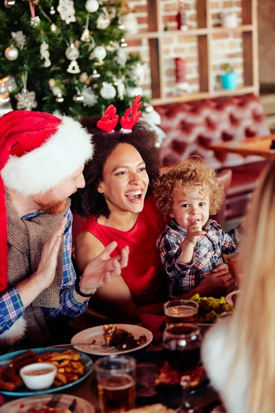 Amigos Dándole Regalo Niño Pequeño Mientras Están Sentados Mesa Árbol —  Fotos de Stock