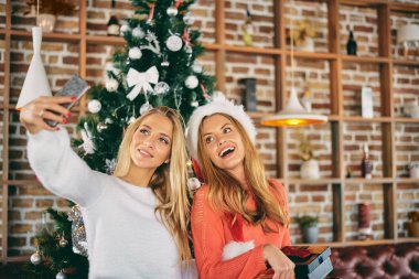 Selfie alma ve hediyeler Noel ağacı önünde duran süre tutan kız. Noel ve kış tatil kavramı.