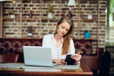 Kafeteryada otururken tablet kullanarak iş kadını. Tablo laptop ve kahve.