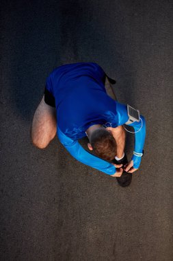 Üstten görünüm sokakta bağcık bağlama koşucu. sağlıklı yaşam konsepti.