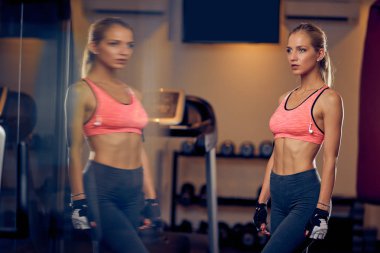 Spor salonunda dururken poz kadın. Sağlıklı yaşam konsepti.