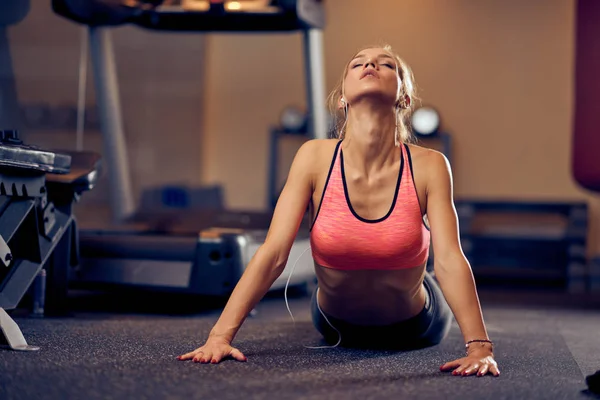 Kvinnan Gör Stretching Övningar Golvet Bakgrunden Gymutrustning — Stockfoto