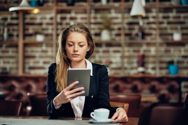 Kafeteryada otururken tablet kullanarak iş kadını. Tablo laptop ve kahve.