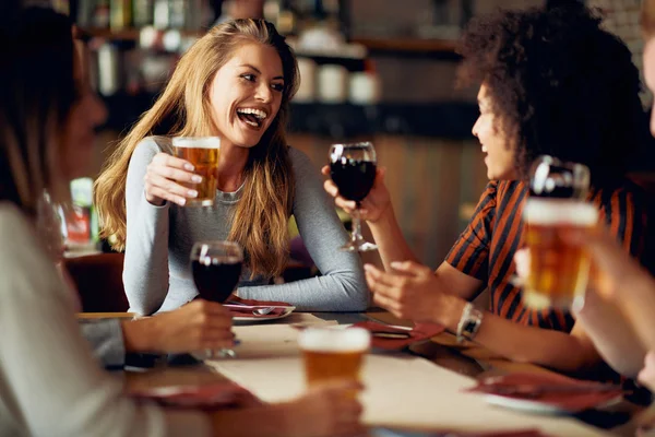 多文化的朋友坐在餐厅里喝葡萄酒和啤酒 — 图库照片