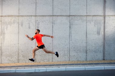 Genç adam sokakta çalıştıran sakallı. Sağlıklı yaşam konsepti.