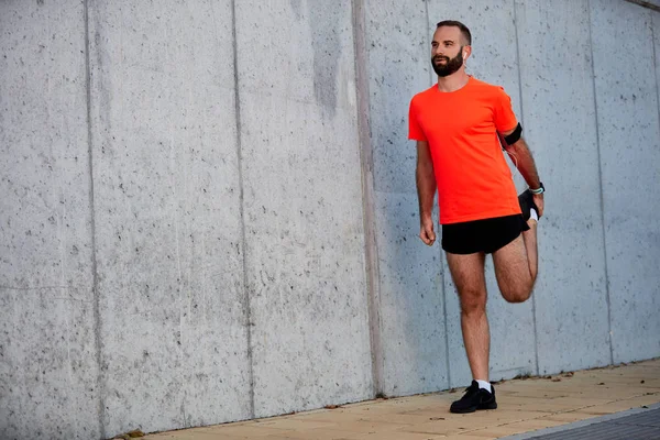 Adamın bacakları çalıştırmadan önce germe kapatın. Sağlıklı yaşam konsepti.