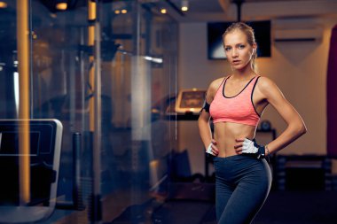 Spor salonunda dururken poz kadın. Sağlıklı yaşam konsepti.