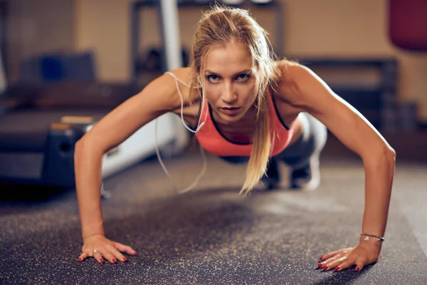Sportliche Frau Macht Liegestütze Auf Dem Boden Hintergrund Übungsgeräte Fitnessstudio — Stockfoto
