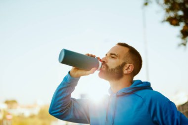 Genç sakallı sportif adam içme suyu yakın çekim. Sağlıklı yaşam konsepti.