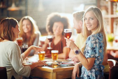 Kameraya bakarak ve şarap restoranda otururken tutan kadın. İçki ve sohbet arka plan arkadaşlar.