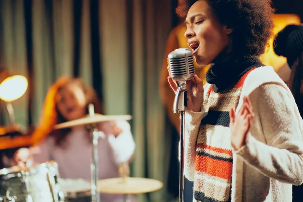 混血女性が歌うをクローズ アップ 背景バンドで楽器を演奏します ホーム スタジオのインテリア — ストック写真