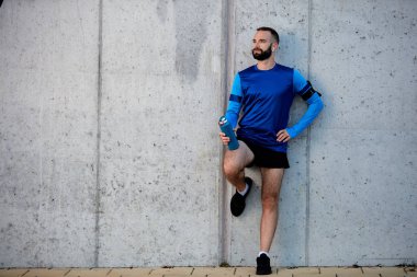Dinlenme ve el holdi duvara karşı duran erkek atlet