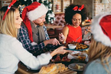 Akşam yemeğinde evde Noel arifesi olan arkadaşlar. Kış tatil kavramı.